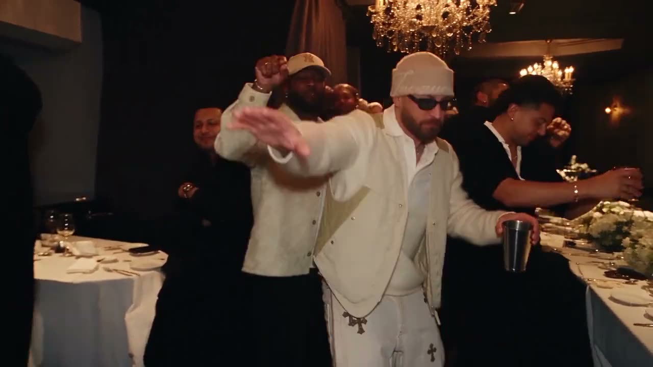 A guy in a white suit and shades takes over the party.